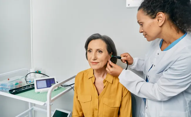 Une personne est en train de se faire contrôler les oreilles chez le médecin pour vérifier son audition