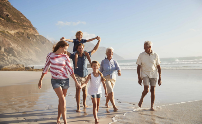 Famille multigénérationnelle marche sur la plage